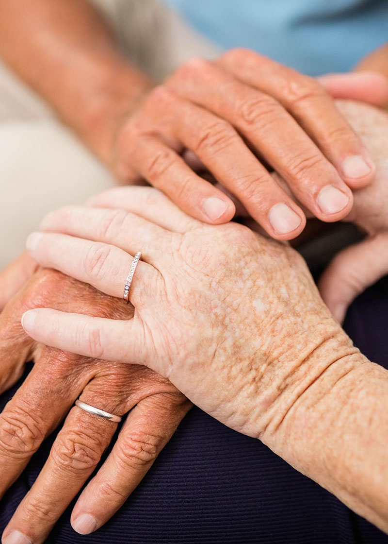 Cute senior couple holding hands on sofa